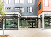 Thumbnail 38 of 40 - A modern building with a grey and orange facade.