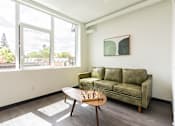 Thumbnail 1 of 54 - A living room with a green couch and a chess set on the table.