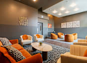 Thumbnail 2 of 54 - A room with orange and white chairs and a black coffee table.