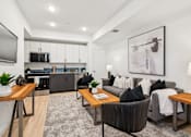 Thumbnail 14 of 78 - A modern living room with a grey couch, a wooden coffee table, and a television on the wall.