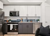 Thumbnail 12 of 78 - A modern kitchen with a black chair and a black pillow.