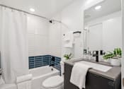 Thumbnail 62 of 78 - A bathroom with a white toilet, a white shower curtain, and a white sink.