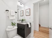 Thumbnail 45 of 78 - A bathroom with a white toilet and a black cabinet.