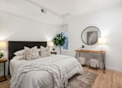 Thumbnail 17 of 78 - A bedroom with a large bed and a desk with a chair.