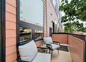 Thumbnail 8 of 78 - A balcony with a chair and a cushion.