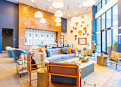 Thumbnail 24 of 29 - A modern living room with a brick wall and a large window.