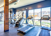 Thumbnail 23 of 29 - A gym with treadmills and a stair climber.