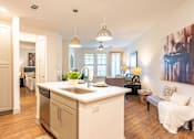 Thumbnail 3 of 29 - A kitchen with a white counter top and a large island.