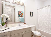 Thumbnail 11 of 29 - A white bathroom with a toilet, sink, and shower.