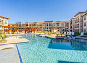 Thumbnail 16 of 29 - A large swimming pool in front of a resort.