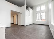 Thumbnail 34 of 40 - A spacious room with a white cabinet and a grey ceiling.