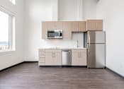 Thumbnail 21 of 40 - A kitchen with a microwave, dishwasher, and refrigerator.