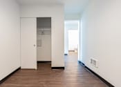 Thumbnail 30 of 40 - A hallway with a white door and a brown floor.