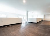 Thumbnail 32 of 40 - A room with a wooden floor and white walls.