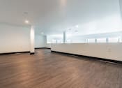 Thumbnail 29 of 40 - A large empty room with wooden floors and white walls.