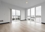 Thumbnail 16 of 40 - A spacious room with a view of the city through large windows.