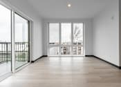 Thumbnail 18 of 40 - A large empty room with a view of the outside through the windows.
