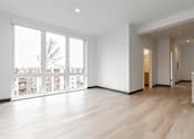 Thumbnail 17 of 40 - A spacious room with a large window and wooden flooring.