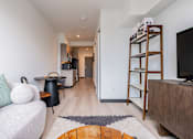 Thumbnail 8 of 40 - A living room with a white couch and a wooden bookshelf.