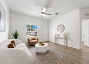 Thumbnail 5 of 15 - Pet-Friendly Townhomes in Kissimmee, FL – Estates at Lake Cecile - A living room with a white couch, a coffee table, and a ceiling fan.