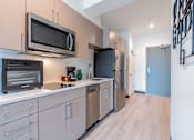Thumbnail 2 of 40 - A kitchen with a black microwave above a black toaster oven.