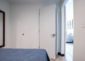Thumbnail 11 of 40 - A bedroom with a bed and a mirror on the wall.