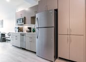 Thumbnail 3 of 40 - A modern kitchen with a refrigerator and cabinets.