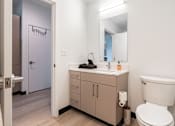 Thumbnail 13 of 40 - A bathroom with a toilet, sink, and mirror.