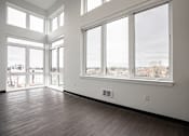Thumbnail 27 of 40 - A room with a view of the city through large windows.
