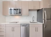 Thumbnail 20 of 40 - A modern kitchen with a stainless steel refrigerator, microwave, and dishwasher.