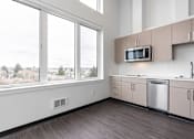 Thumbnail 25 of 40 - A kitchen with a microwave on the counter and a dishwasher underneath it.