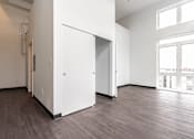 Thumbnail 23 of 40 - A white door is open in a room with wood flooring.