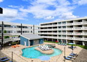 Thumbnail 37 of 51 - A large apartment complex with a pool and hot tub.
