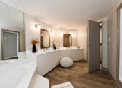 Thumbnail 7 of 51 - A white bathroom with a large tub and a vanity with a mirror.