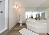Thumbnail 9 of 51 - A white bathroom with a toilet, sink, and bathtub.