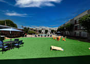 Thumbnail 33 of 51 - A playground with a green surface and various pieces of play equipment.