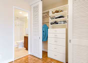 Thumbnail 31 of 66 - A white closet with a blue shirt hanging on the door.