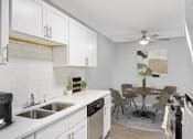 Thumbnail 4 of 14 - Stratford Wood Apartments and Townhomes in Minnetonka, MN Photo of  an open kitchen and dining area with a table and chairs and a sink