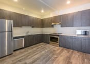Thumbnail 7 of 18 - a kitchen with wooden cabinets and stainless steel appliances