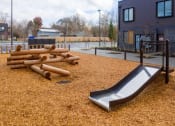 Thumbnail 14 of 18 - a slide and logs in a playground