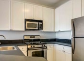 Thumbnail 4 of 38 - Kitchen with white cabinets and stainless steel appliances