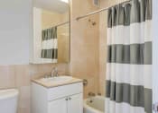 Thumbnail 9 of 38 - Model apartment bathroom with vanity and tub shower
