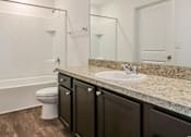 Thumbnail 62 of 75 - A white toilet sits in a bathroom with a marble countertop.