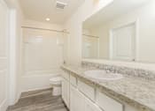 Thumbnail 23 of 38 - A white bathroom with a toilet, sink, and mirror.