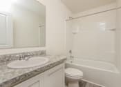Thumbnail 31 of 38 - A white bathroom with a sink, toilet and bathtub.