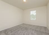 Thumbnail 32 of 38 - A room with a carpeted floor and a window with blinds.