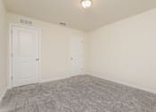 Thumbnail 21 of 38 - A room with two doors and a carpeted floor.