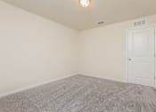Thumbnail 16 of 38 - A room with a carpeted floor and a white door.