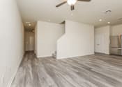 Thumbnail 11 of 38 - A room with a ceiling fan and a refrigerator.