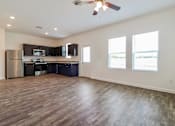 Thumbnail 58 of 75 - A spacious kitchen with dark wood floors and stainless steel appliances.